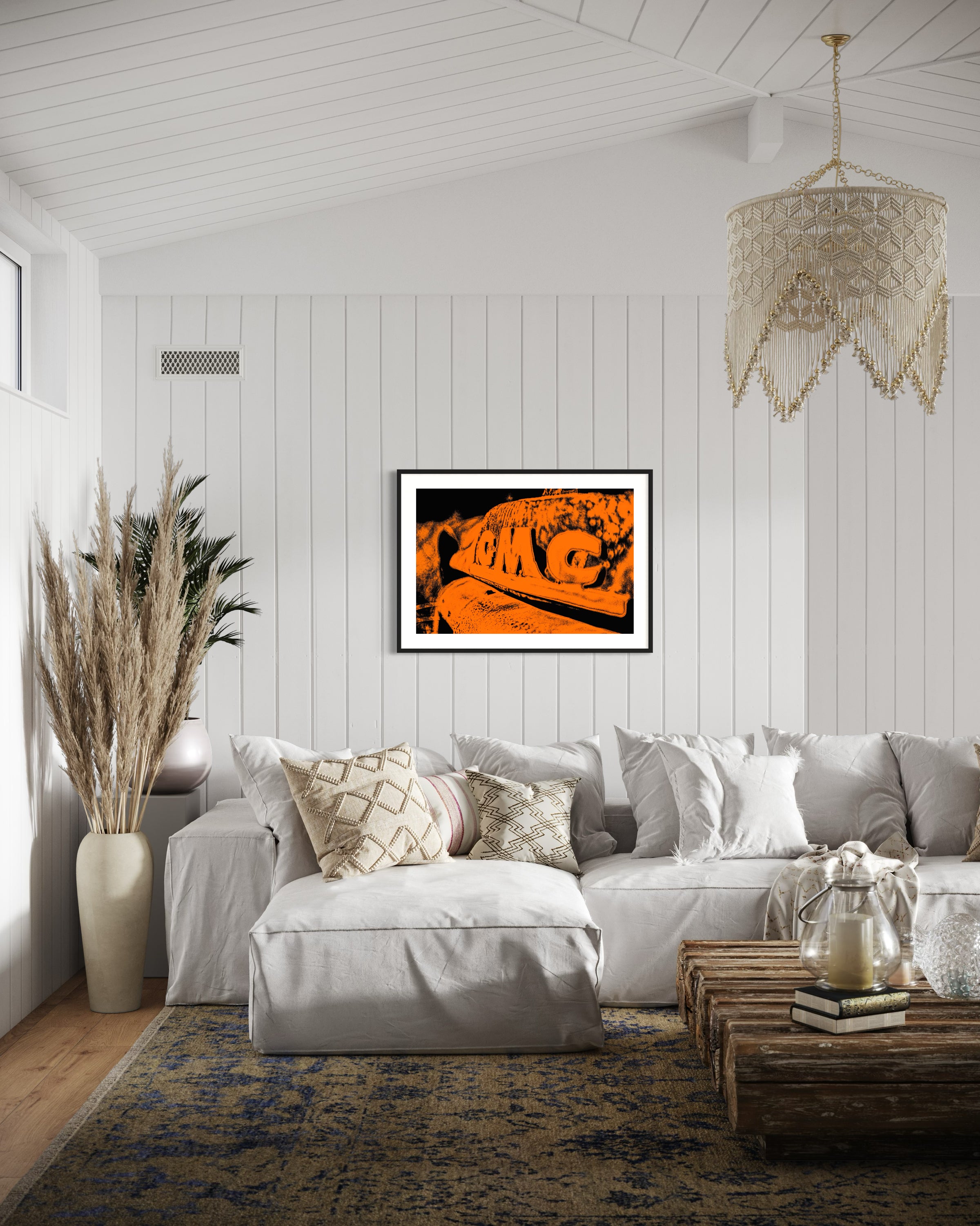orange tone photo of front of old truck in black frame with white matte on white wall in beach style living room with white and earth tones