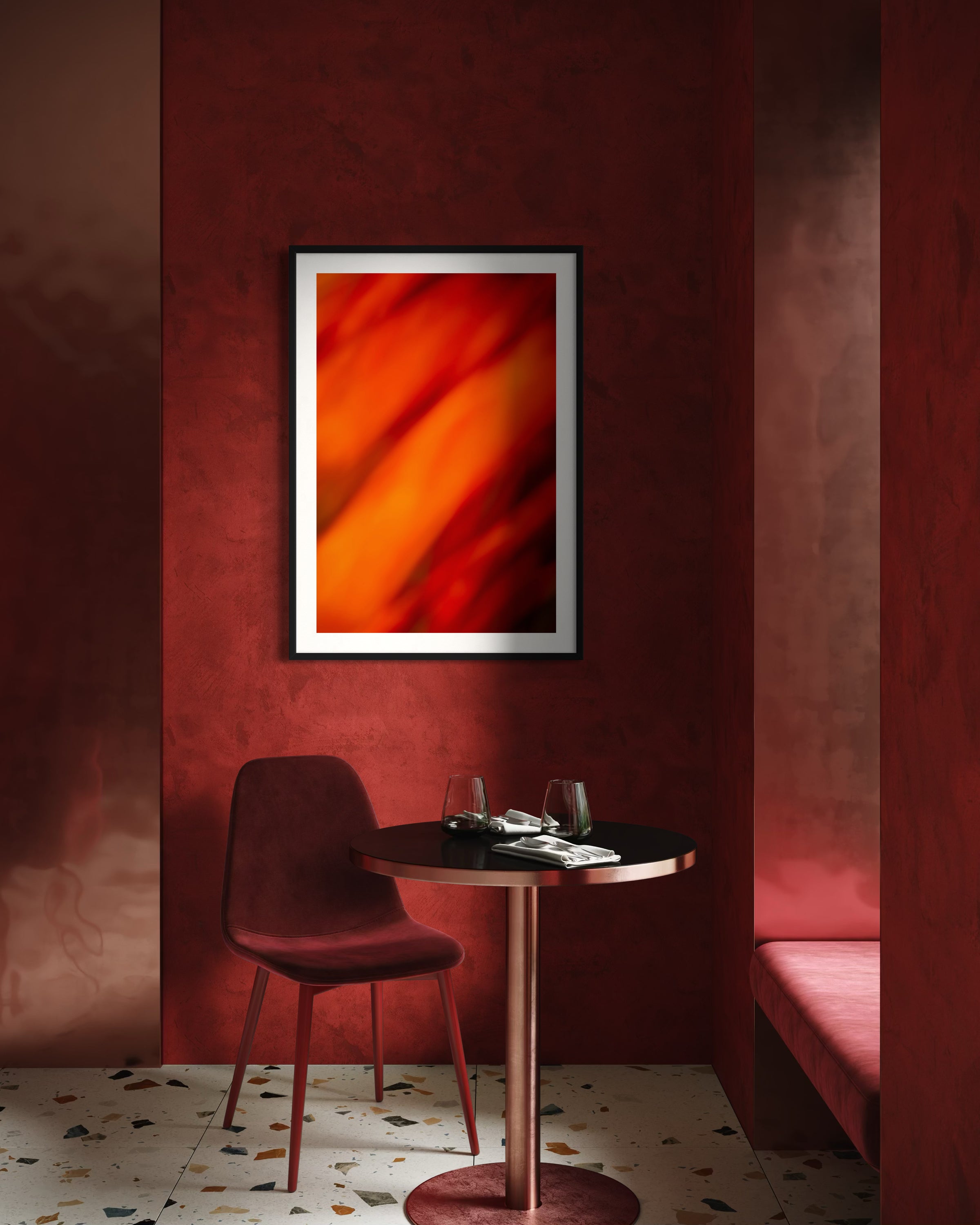 A cozy red interior features a round table set with glasses and napkins, a red chair, and a vibrant abstract artwork on the wall, conveying warmth.