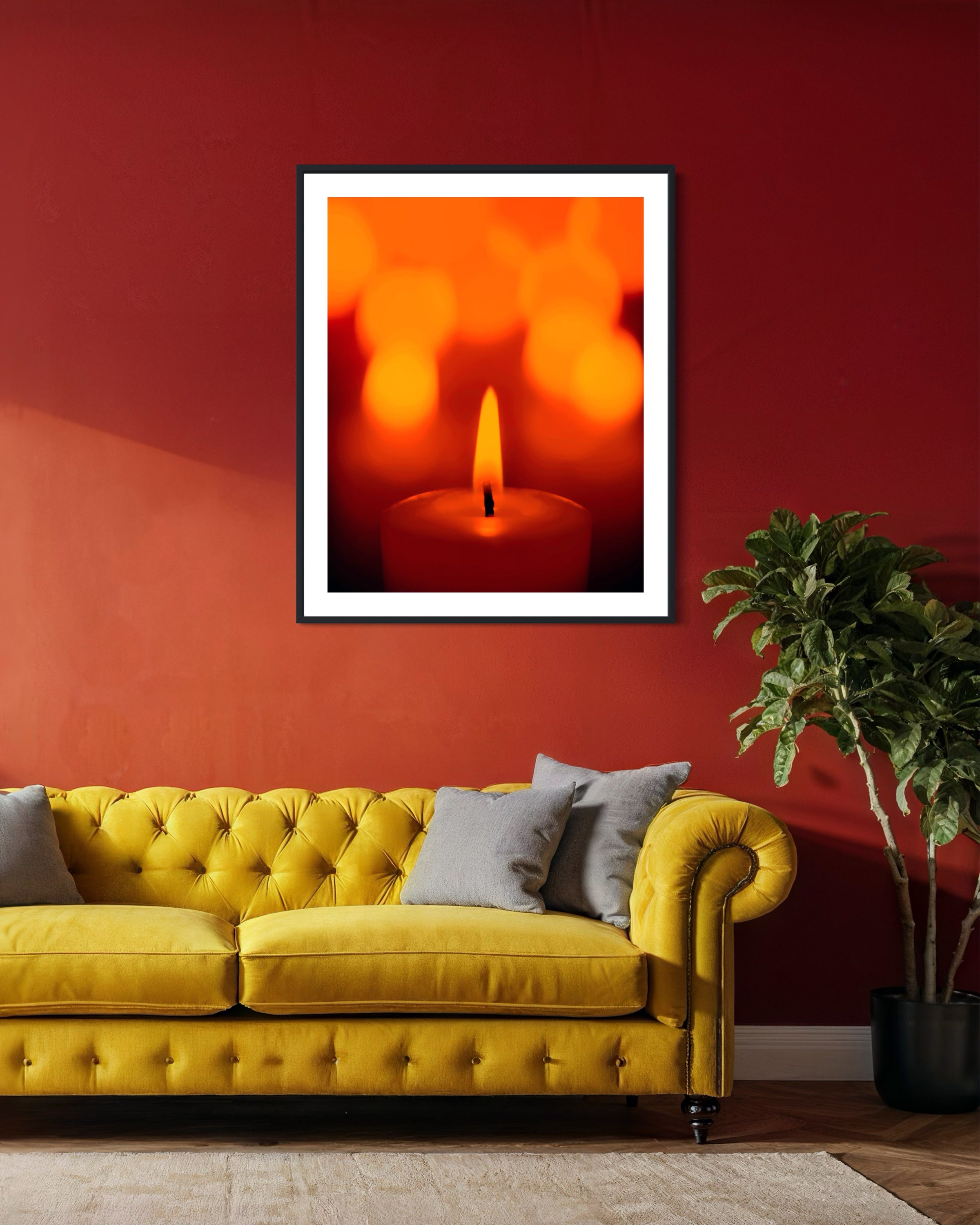 Yellow sofa with gray cushions against a red wall with a framed abstract art piece.