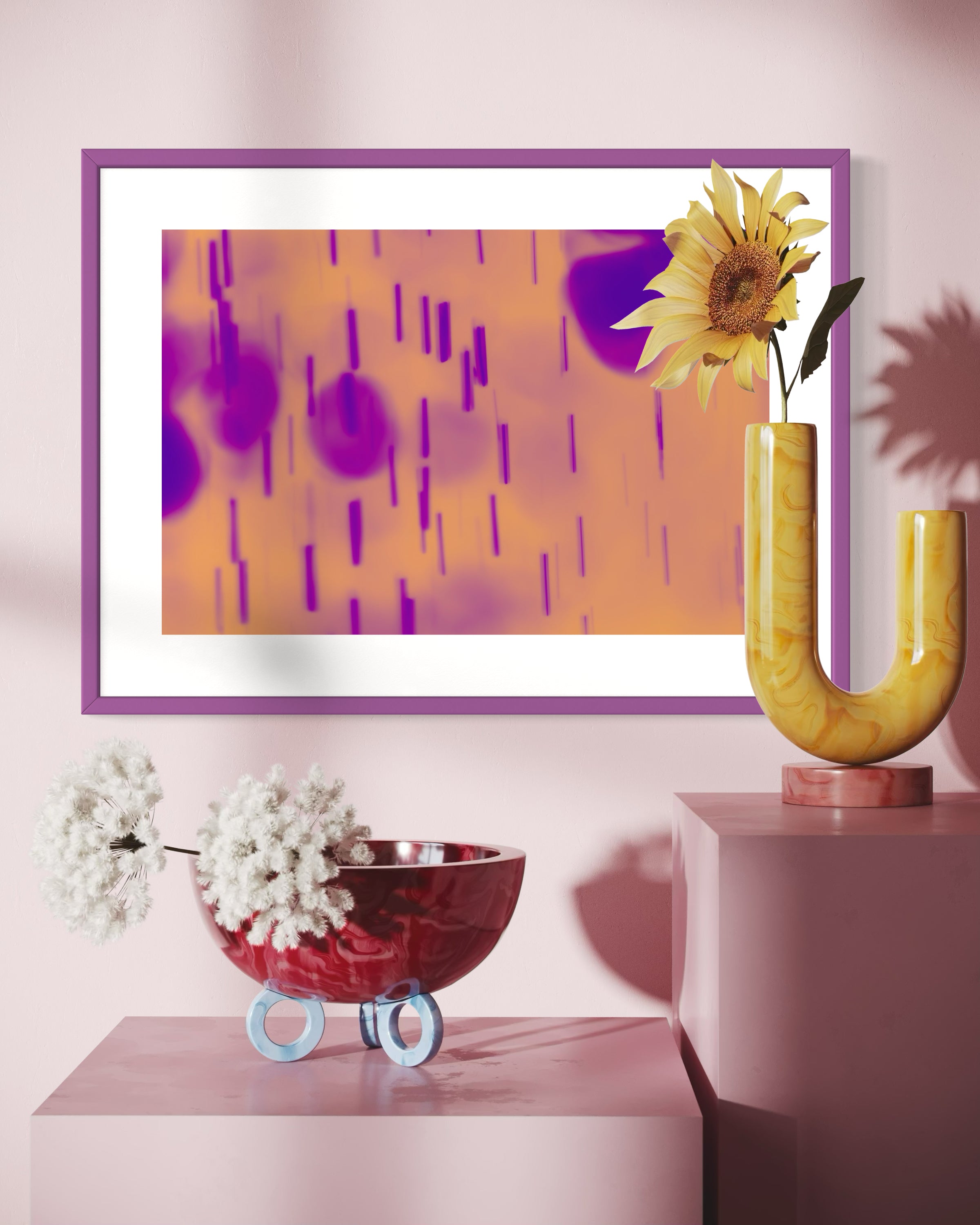 blurred rain in purple on pale yellow background in purple frame with white matte on pink wall above two large pink cubes with a few flowers on top