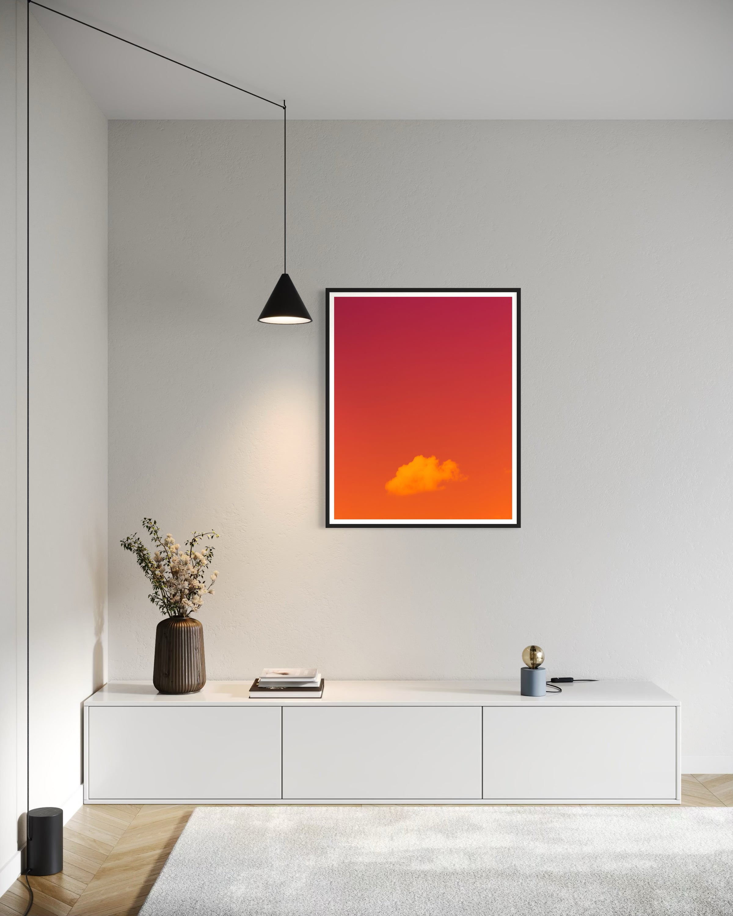 warm tone photo of single cloud in black frame with white matte on white wall in office area in minimalist home with white tones and light colored hardwood floors 
