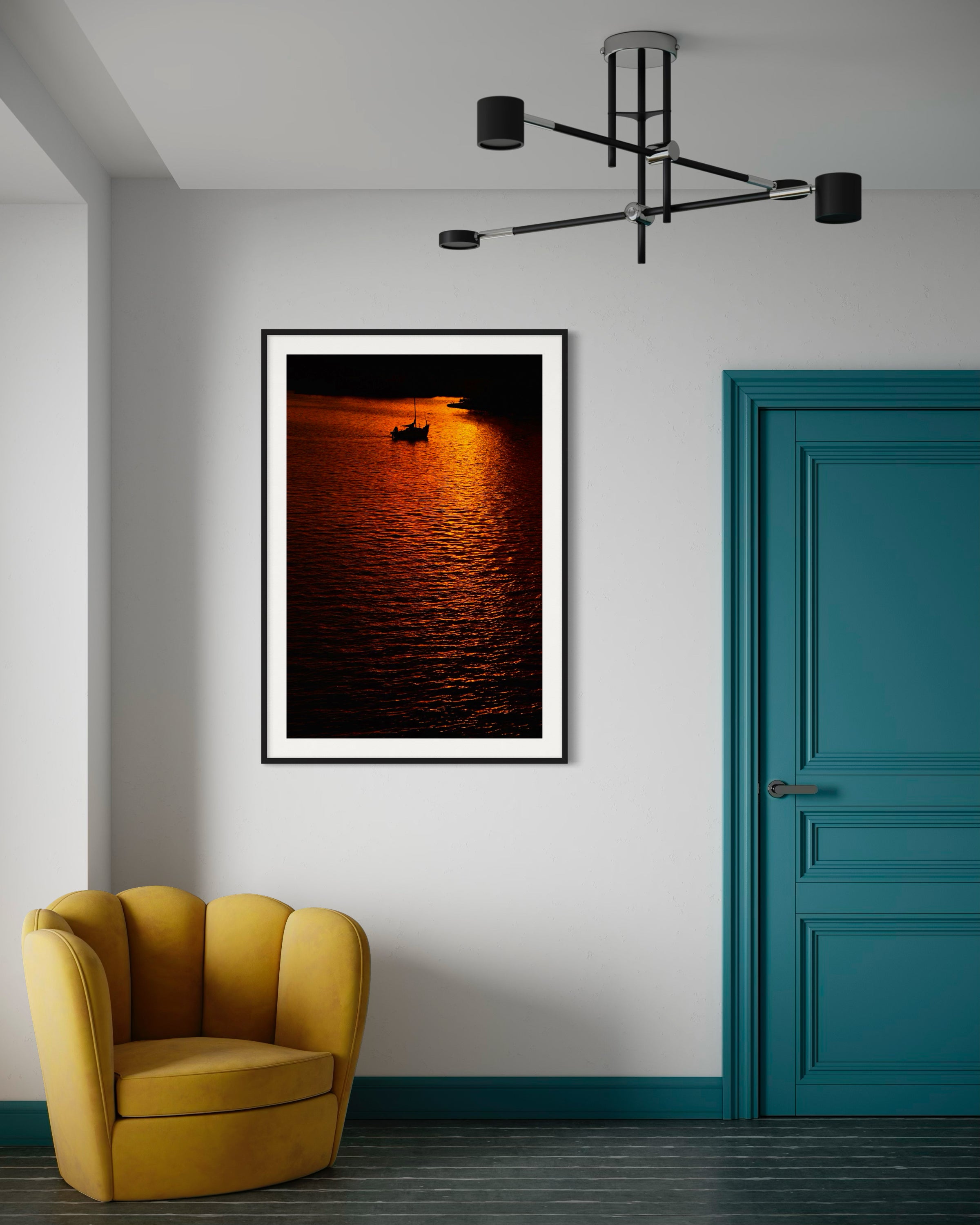 Framed artwork of a sunset over water in a modern room with a yellow chair and teal door.