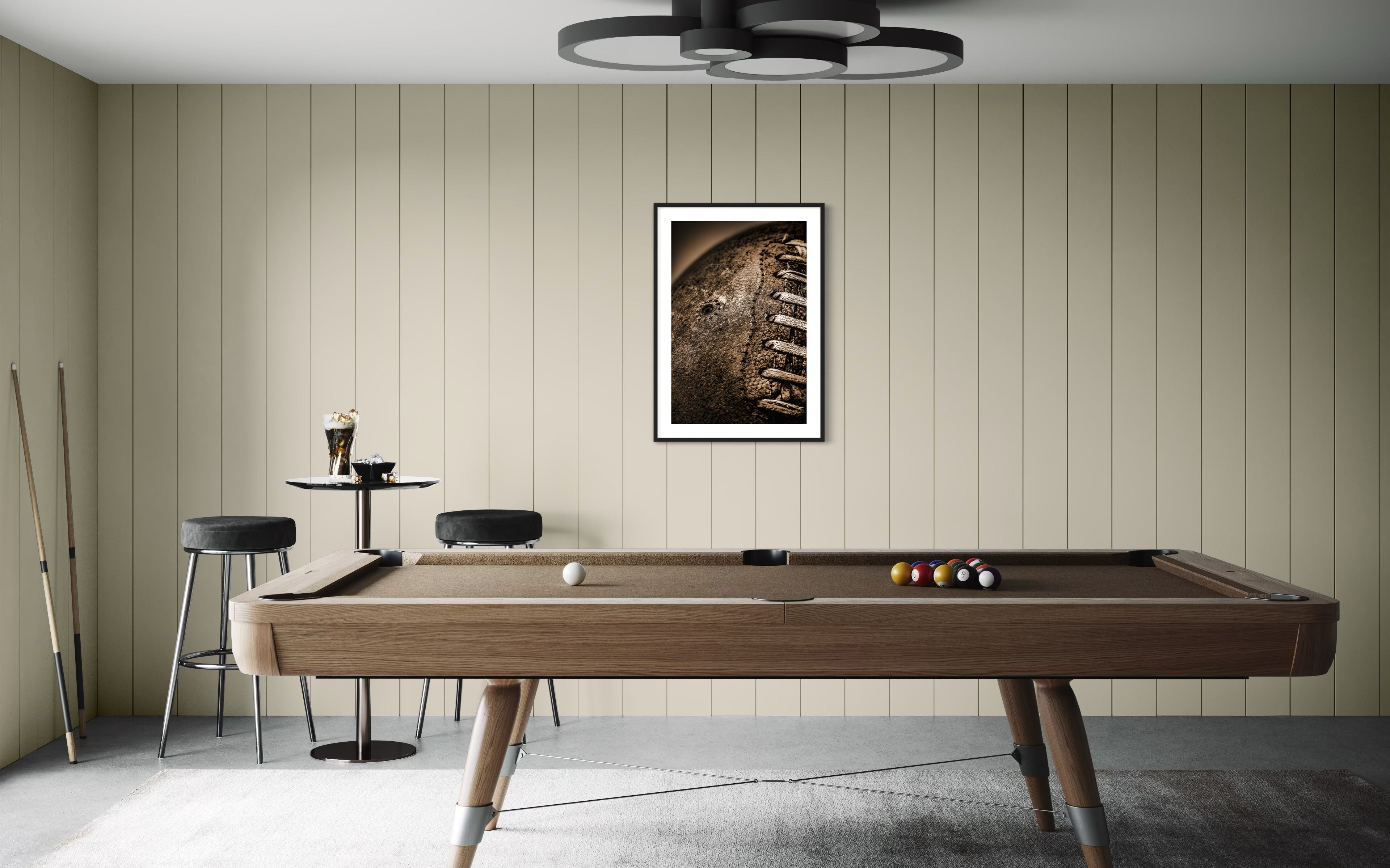 Sepia tone old football close up in a grungy look shot in studio in black frame with white matte on tan wall in game room with pool table and concrete floors