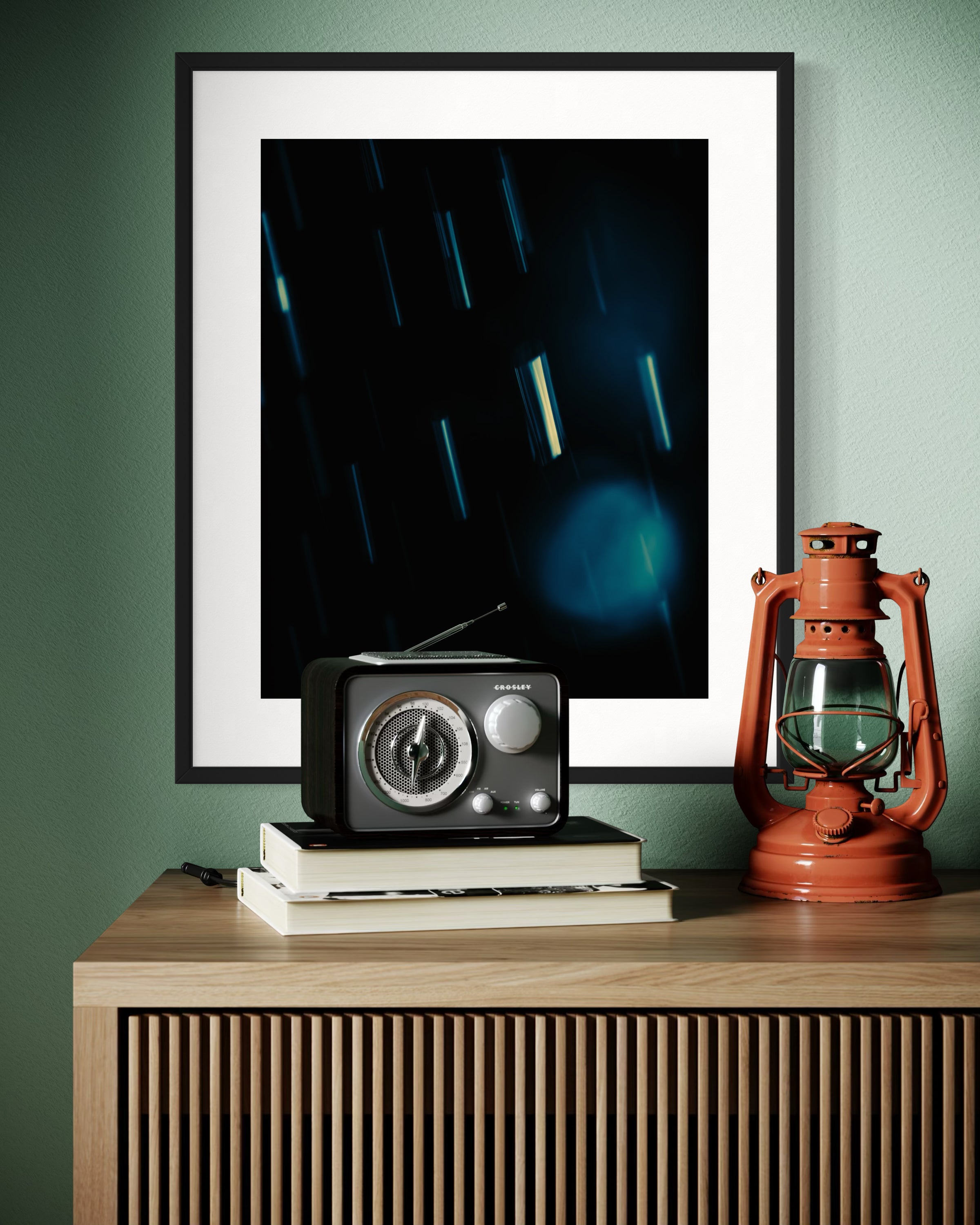 close up cool toned photo of streaks of rain in black frame with white matte on light green wall above modern wooden table