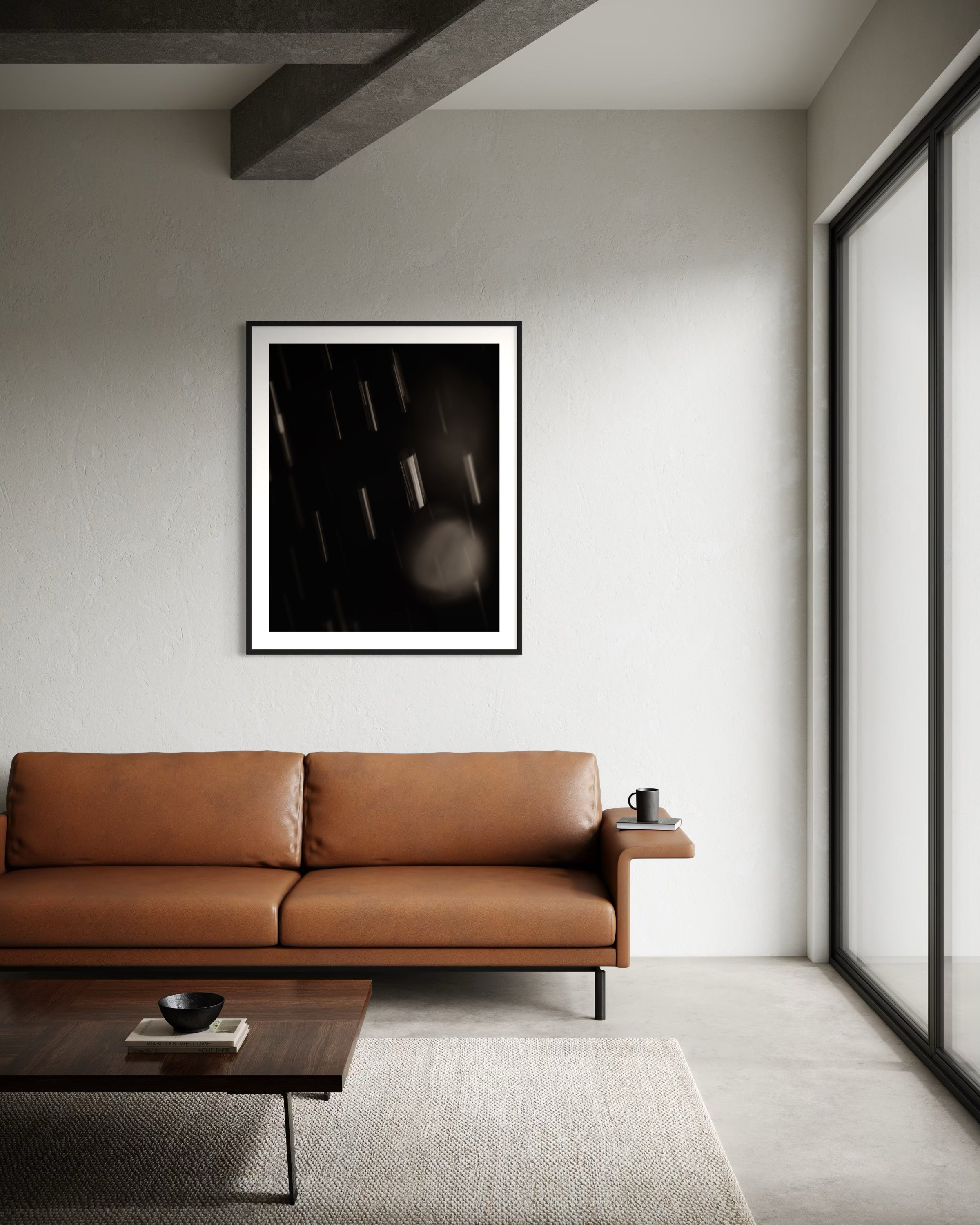 close up warm toned photo of streaks of rain in black frame with white matte on light gray wall in minimalist modern living room with leather sofa, wooden coffee table and concrete floors